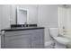 Bathroom features a gray vanity, dark countertop, toilet, and bathtub with shower at 11643 Sarah Loop, Hampton, GA 30228