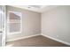A well-lit bedroom features a window with blinds, neutral walls, and a neutral carpet at 11643 Sarah Loop, Hampton, GA 30228