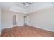 Primary bedroom features tray ceilings, wood flooring, and en-suite bathroom entrance at 11643 Sarah Loop, Hampton, GA 30228