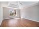 Primary bedroom features tray ceilings, a window, and wood-look flooring at 11643 Sarah Loop, Hampton, GA 30228