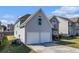 View of the home's side and back featuring a two-car garage and well-kept lawn at 11643 Sarah Loop, Hampton, GA 30228