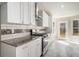 A modern kitchen offers white cabinets, stainless steel appliances, granite countertops and tile backsplash at 11643 Sarah Loop, Hampton, GA 30228
