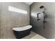 Modern bathroom features a soaking tub, a window, and a sleek black shower system at 1742 Ridgeway Nw Ave, Atlanta, GA 30318