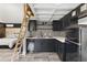 A kitchenette with black cabinets, contrasting tile backsplash, and a ladder to the loft at 1742 Ridgeway Nw Ave, Atlanta, GA 30318