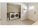 Well-lit laundry room boasts modern washer and dryer, storage shelves, and convenient access to an exterior door at 1742 Ridgeway Nw Ave, Atlanta, GA 30318
