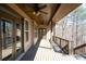 Large covered back porch featuring ceiling fans, exterior stairs, and beautiful wooded views at 702 Ridgeway Ct, Canton, GA 30114