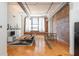 Open concept living room with exposed brick, hardwood floors, and large windows at 87 Peachtree Sw St # 204, Atlanta, GA 30303