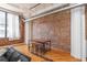 Living room view showcases brick wall, hardwood floors, large windows and counter-height table at 87 Peachtree Sw St # 204, Atlanta, GA 30303