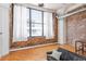 Bright living room featuring exposed brick, hardwood floors, and a large window with natural light at 87 Peachtree Sw St # 204, Atlanta, GA 30303