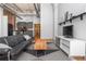 Modern living room featuring hardwood floors, exposed brick, and an open layout to the kitchen at 87 Peachtree Sw St # 204, Atlanta, GA 30303
