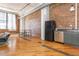 Open concept living room with exposed brick, hardwood floors, and black appliances at 87 Peachtree Sw St # 204, Atlanta, GA 30303