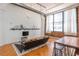 Modern living room with a large window, exposed brick accent wall and stylish furnishings at 87 Peachtree Sw St # 204, Atlanta, GA 30303