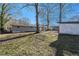 The spacious backyard has grass, trees, and a storage shed at 1496 Greenwillow Dr, Conley, GA 30288