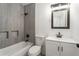 A renovated bathroom features gray tiling, modern fixtures, and a clean aesthetic at 1496 Greenwillow Dr, Conley, GA 30288