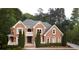 Stately brick home with a symmetrical facade, Juliet balcony, manicured landscaping, and elegant architectural details at 2650 Riverfront Dr, Snellville, GA 30039