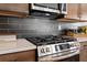 Close-up view of the stainless steel gas range and microwave, complemented by modern backsplash and countertop at 523 Lanier Way, Temple, GA 30179
