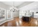 Kitchen and dining area with white cabinets, dark wood island, and modern lighting at 925 Sentry Ridge Xing, Suwanee, GA 30024