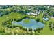 Drone's eye view of a green golf course featuring a pond, swimming pool and clubhouse at 10 Chaumont Nw Sq, Atlanta, GA 30327