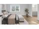 Cozy bedroom with natural light, wood floors, plush bedding, and adjacent bathroom at 10 Chaumont Nw Sq, Atlanta, GA 30327