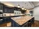 A gorgeous eat-in kitchen with a granite island, stainless appliances, and stunning dark cabinets and hardwood floors at 1466 University Dr, Atlanta, GA 30306