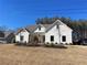 Charming white farmhouse-style home with a well-manicured front yard and a welcoming porch at 3415 Henderson Dr, Cumming, GA 30041