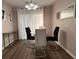 Dining area featuring modern light fixture, a glass table, and neutral tones at 5609 Windwood Rd, Atlanta, GA 30349