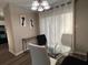 Dining area featuring modern light fixture, a glass table, and neutral tones at 5609 Windwood Rd, Atlanta, GA 30349