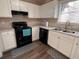 Bright kitchen with white cabinets, modern appliances, and a window view at 5609 Windwood Rd, Atlanta, GA 30349