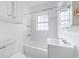 Bright bathroom featuring a tub and shower combination, crisp white tiling, and large window for natural light at 795 Ponce De Leon Ne Pl # C3, Atlanta, GA 30306