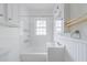The bathroom has white tile floors and walls and a shower and sink at 795 Ponce De Leon Ne Pl # C3, Atlanta, GA 30306