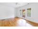 Bright empty room featuring hardwood floors, white walls, and doors leading to balcony at 795 Ponce De Leon Ne Pl # C3, Atlanta, GA 30306