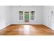 Vacant room with hardwood floors, neutral walls, and French doors to outdoor balcony at 795 Ponce De Leon Ne Pl # C3, Atlanta, GA 30306
