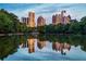 Picturesque view of the city skyline reflecting on a serene lake surrounded by lush greenery at 795 Ponce De Leon Ne Pl # C3, Atlanta, GA 30306