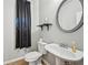 Powder room featuring a pedestal sink, oval mirror, and dark curtain at 2726 Pierce Brennen Ct, Lawrenceville, GA 30043