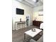 Living room showing hardwood floors, dresser, TV and view into galley kitchen at 32 Peachtree Nw St # 202, Atlanta, GA 30303