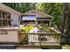 Multi-level deck with outdoor dining area and integrated grill surrounded by mature trees and greenery at 385 Grimes Bridge Rd, Roswell, GA 30075