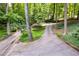 Long driveway leading to a secluded home through a lush forest with ample parking and natural beauty at 385 Grimes Bridge Rd, Roswell, GA 30075