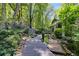 Exterior with wood walkway, trees, and a landscaped yard at 385 Grimes Bridge Rd, Roswell, GA 30075
