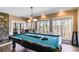 Spacious game room with pool table, stone fireplace, and views of the natural setting at 385 Grimes Bridge Rd, Roswell, GA 30075