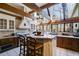 Open-concept kitchen with an island, wooden beams, and expansive windows with nature views at 385 Grimes Bridge Rd, Roswell, GA 30075