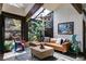 Cozy living room featuring a leather sectional, unique lighting, and tranquil views of lush greenery at 385 Grimes Bridge Rd, Roswell, GA 30075