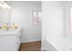 Bright bathroom boasts double vanity with quartz counters, bathtub, and light wood grain flooring at 5050 Brownwood Dr, Powder Springs, GA 30127