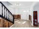Inviting foyer with wood-look flooring, decorative wood trim, and a staircase with black railings at 5050 Brownwood Dr, Powder Springs, GA 30127