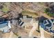 Birds eye view of a home with a large driveway, landscaping, a fire pit and neighboring houses at 114 Rock Creek Ln, Canton, GA 30114