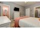 Bedroom with a twin bed, TV, dresser, and a doorway leading to a bathroom with pink walls and an oval mirror at 114 Rock Creek Ln, Canton, GA 30114