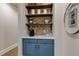 Cozy coffee bar with blue cabinetry, open shelving, brick backsplash, and stylish decor at 114 Rock Creek Ln, Canton, GA 30114