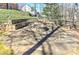 Charming stone fire pit area with built-in seating surrounded by lush landscaping at 114 Rock Creek Ln, Canton, GA 30114