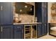 Finished basement kitchenette with blue cabinets, brick backsplash and stainless steel beverage cooler at 114 Rock Creek Ln, Canton, GA 30114