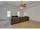 Living room featuring a large sectional sofa, two windows letting in natural light, and a ceiling fan with lights at 114 Rock Creek Ln, Canton, GA 30114