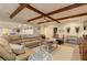 Living room with wood beam ceilings, a sectional sofa, modern furniture, and stylish decorations at 114 Rock Creek Ln, Canton, GA 30114